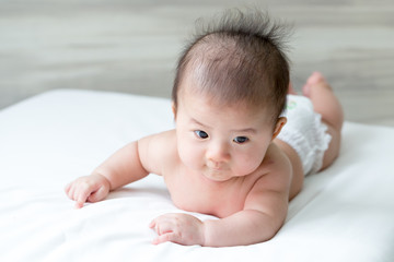 Adorable asian baby boy relaxing on white bed, Baby development stages of 3 month old