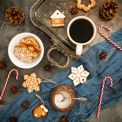 Christmas or New year food concept. Gingerbread, candy canes and coffee cup on dark background. Flat lay. Top view