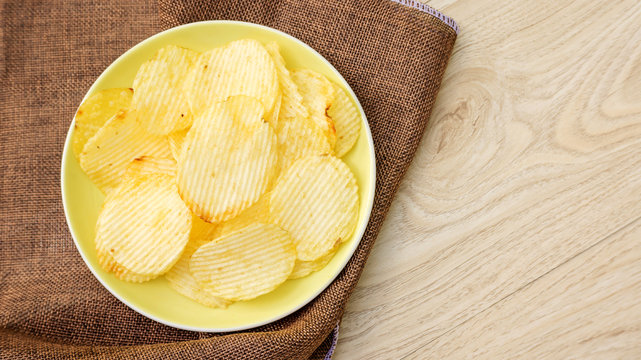 potatoes chips on a wooden table.
