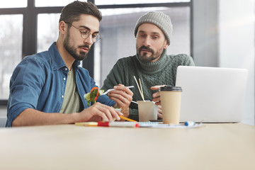 Staff memebers brainstrom together, have lunch break, finish tasks, look seriously at notes, collaborate and cooperate, have lucnchtime at modern office. People, food, business and people concept