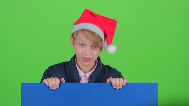 Teen in cap rises holding hands for the board on a green screen