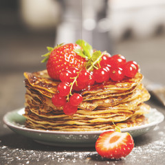 Homemade pancakes with fresh berries and honey