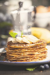 Homemade pancakes with fresh bananas, blueberries and honey