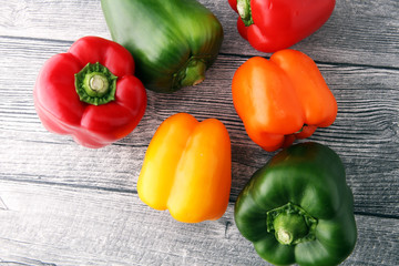 Red, green and yellow sweet bell peppers on table.