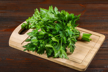 A bunch of green parsley on a wooden table.