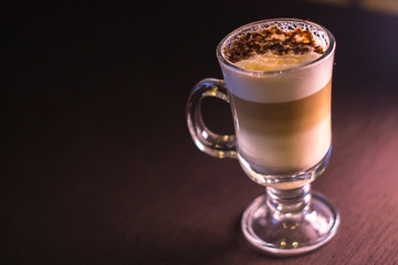 Coffee in a glass cup in a cafe with a blurred background.