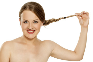 a young happy woman showing her braided hair on white background