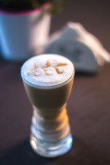 Coffee in a glass cup in a cafe with a blurred background.