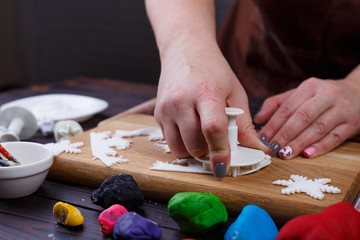 Process of cutting decorations in form of snowflakes of confectionery mastic, close up. Family...