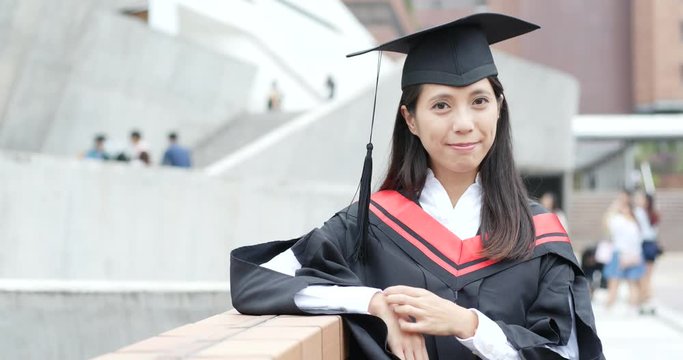 Woman wearing graduation gown in university campus