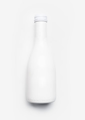 White champagne bottle on white desk background, top view. Minimal party layout or holidays mock up