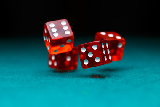 Photo of four playing red dices on green table