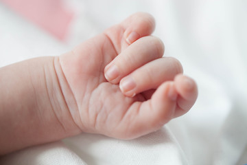 Hand the sleeping baby in the hand of mother close-up.