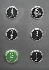 Generic series of metal elevator buttons shot straight on. © Stephen
