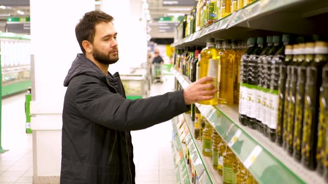  man buys oil at the supermarket. 