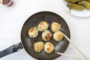 Fried dumplings in a frying pan.