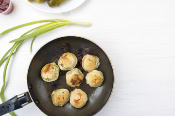 Fried dumplings in a frying pan.
