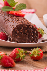 Chocolate roll with hazelnuts and strawberries. 