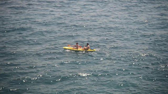 Liguria Italy sea Shore - two people ride a Canoe