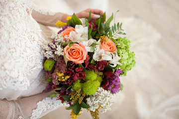 beautiful wedding bouquet with roses in bride's hands.