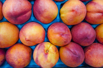 A pile of nectarines in the package in supermarket (background)