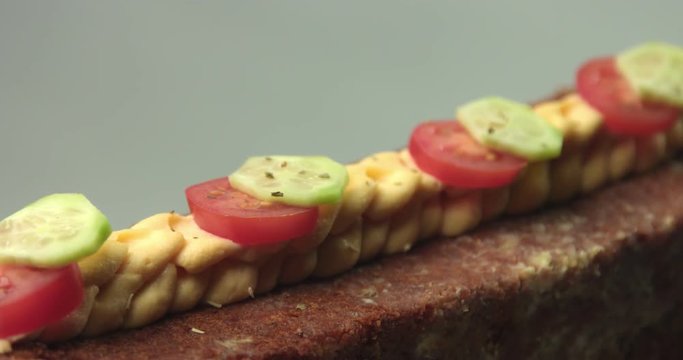 Long rectangular homemade wheat bread with olive oil, bechamel sauce, tomatoes and cucumbers