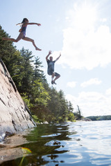 Kids jumping into the river during a camping trip