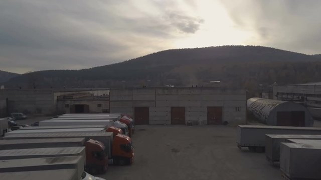 Drone view truck with freight container driving out from parking after unloading