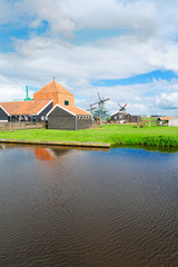 Fototapeta na wymiar traditional Dutch rural scene with canal and windmills of Zaanse Schans, Netherlands