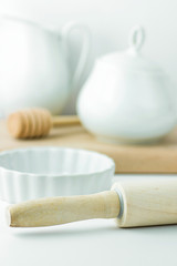 Baking Essentials Utensils on White Tabletop Bowl Wood Rolling Pin Honey Dipper Jug Pitcher Cutting Board. Holiday Christmas Easter. Kitchen Interior