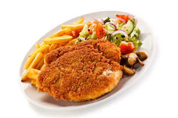 Fried pork chop, French fries and vegetables 