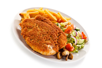 Fried pork chop, French fries and vegetables 