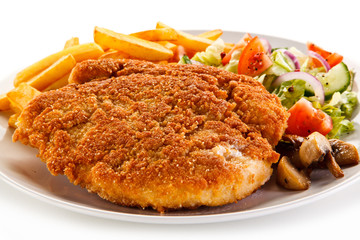 Fried pork chop, French fries and vegetables 