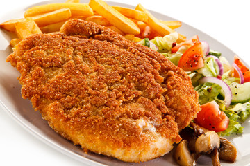 Fried pork chop, French fries and vegetables 