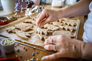Woman making Christmas gingerbread cookies in kitchen