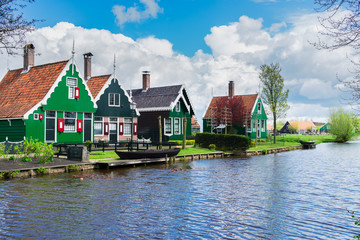 Fototapeta na wymiar rural dutch scenery of small traditional houses in Zaanse Schans with canal, Netherlands