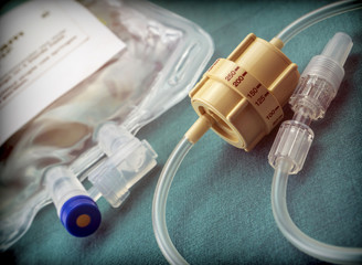Dial flow regulator next to medicine bag in a hospital, conceptual image