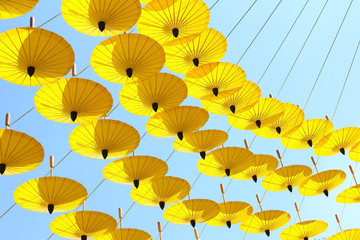 Fototapeta na wymiar yellow umbrella on blue sky with clouds