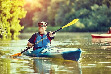 Foto op Canvas  Man paddling a kayak on summer day. © 6okean