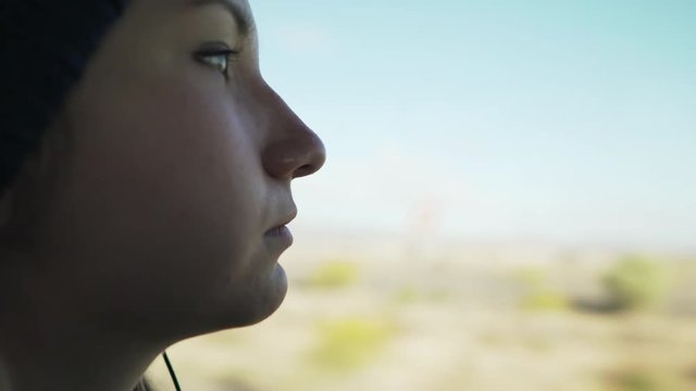 gimbal shot of happy teen girl listening to music in sunny day traveling by bus