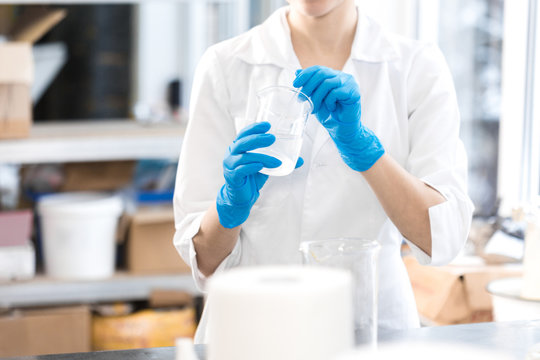 Small Business People At Work. Young Woman Working At The Laboratory Of Cosmetic Production. Mixing Ingredients. Young Technologist Making Face Care Creams. Private Small Cosmetic Products Factory.