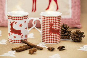 Christmas composition – mugs with deer motive, cinnamon sticks, anise and pinecones.