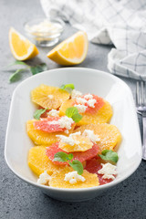 Healthy dessert citrus salad with spicy honey dressing on stone concrete background. Selective focus, copy space. 