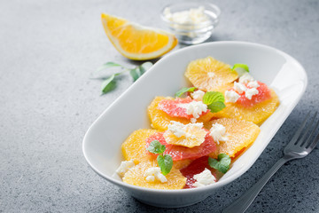 Winter citrus orange grapefruit salad on stone concrete background. Selective focus, copy space. 