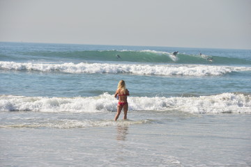 Fototapeta premium A girl by the sea at Huntington beach in California