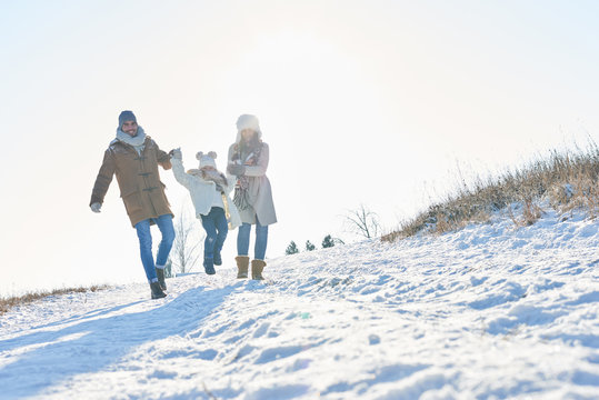 Glückliche Familie geht im Schnee spazieren