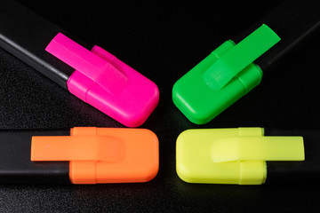 Office Highlighter on a black background. Office Mazak to draw are lying on a black countertop.