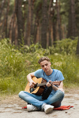 Music lifestyle man playing guitar concept. Stroller man at the nature.