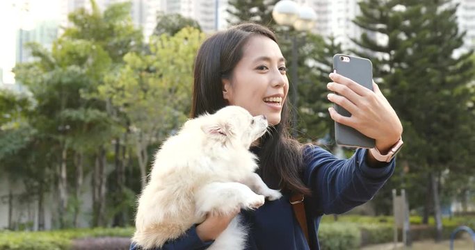 Woman taking selfie with her dog at park