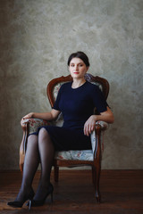 Young beautiful girl sitting on a chair in a loft style